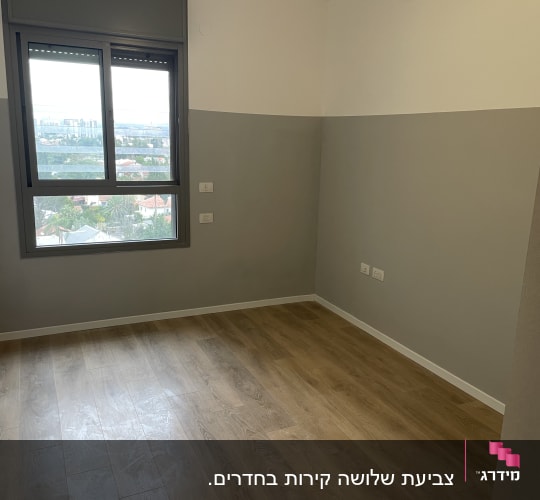 חדר צבוע עם קירות בגוונים שונים ורצפת עץ